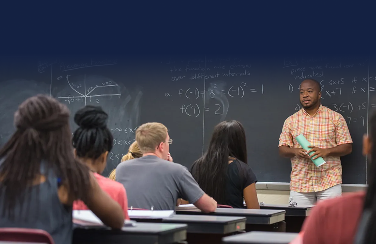 math teacher teaching in front of a blackboard