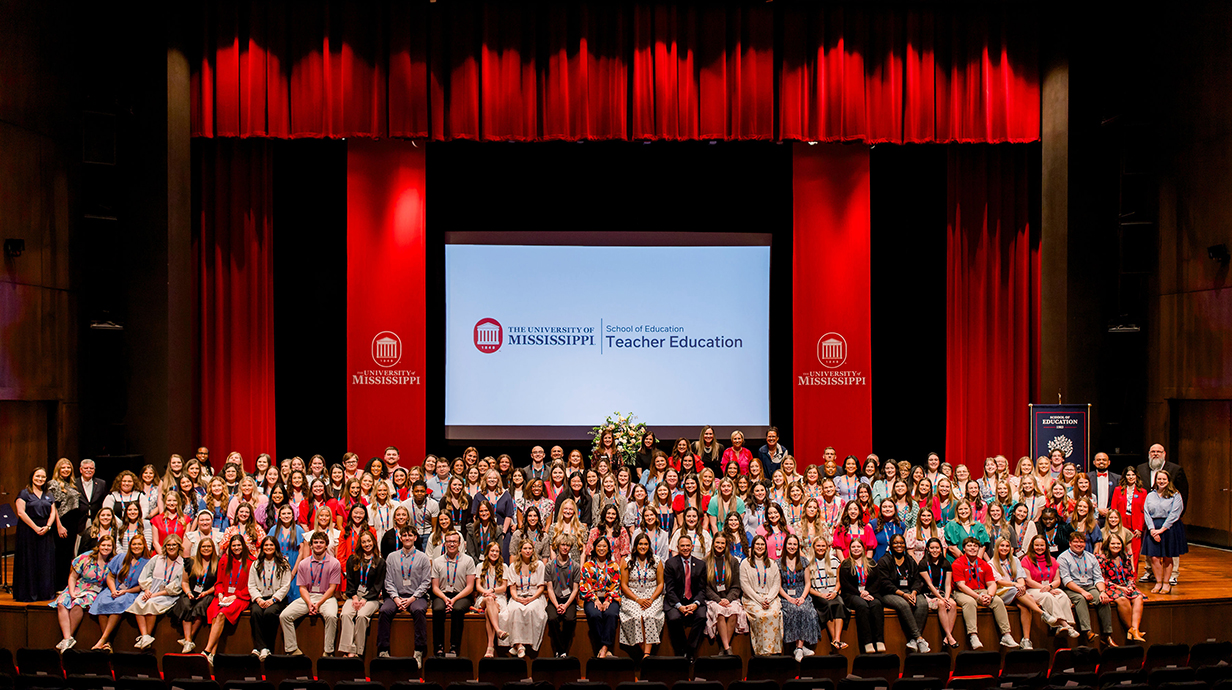 Students and Faculty sit on the state after the Junior Pinning Ceremony